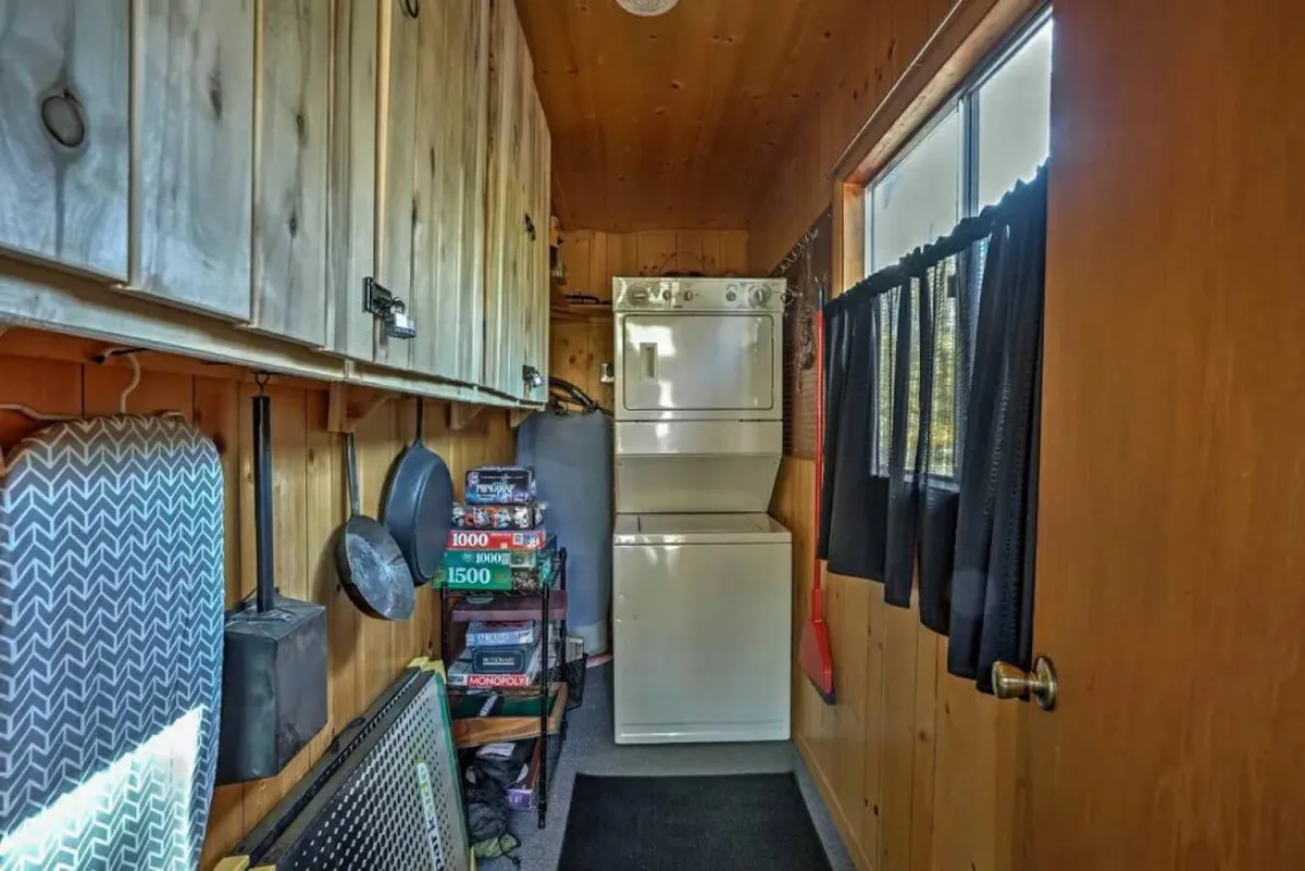 A functional laundry area with a washer, dryer, and wooden cabinets, offering practical amenities for families traveling with pets. The space feels efficient yet homey, suggesting convenience for cleaning up after outdoor play with pets.